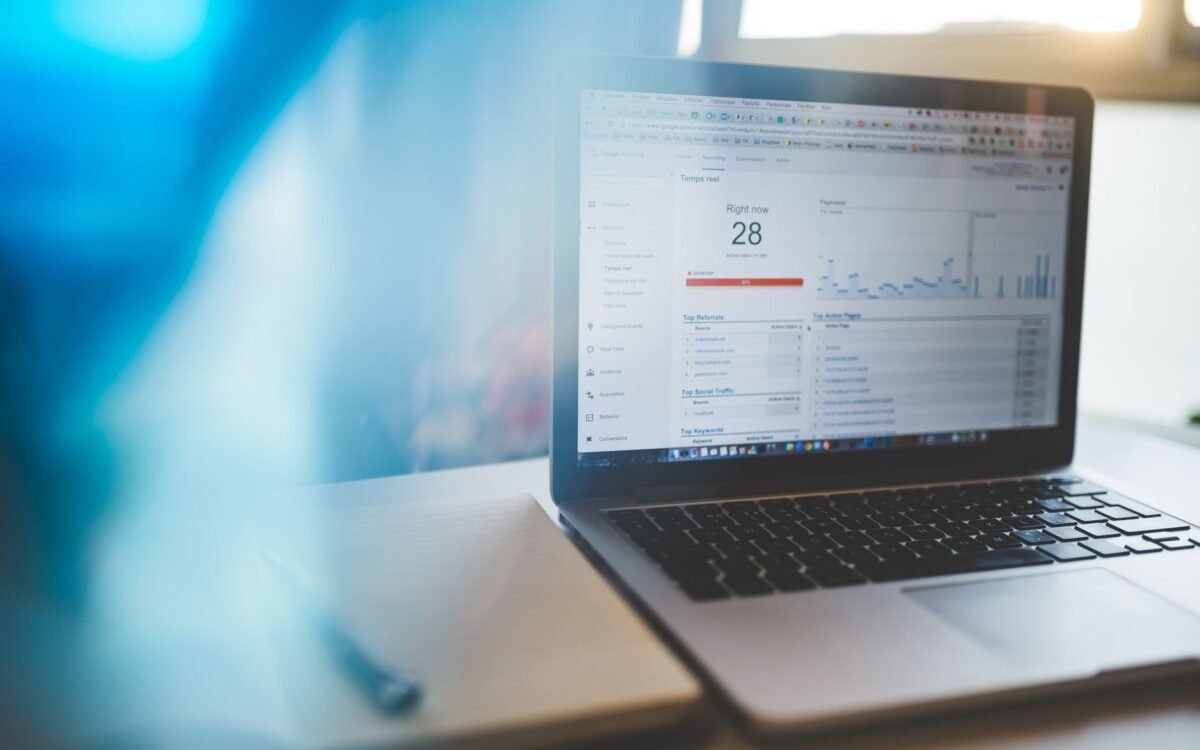 Gestor de pousada analisando gráfico de reservas diretas em dashboard de sistema de booking hoteleiro em São José
